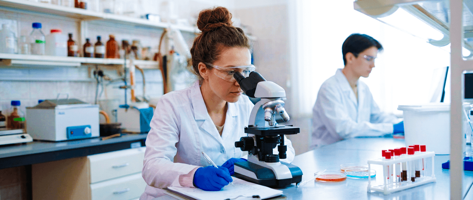 Healthcare researchers working with a microscope in a laboratory.